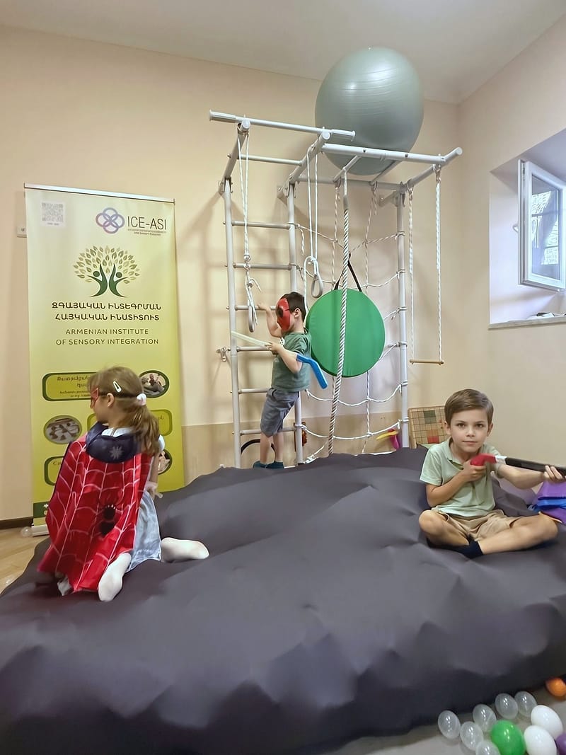Дети занимаются у шведской стенки на мягком мате